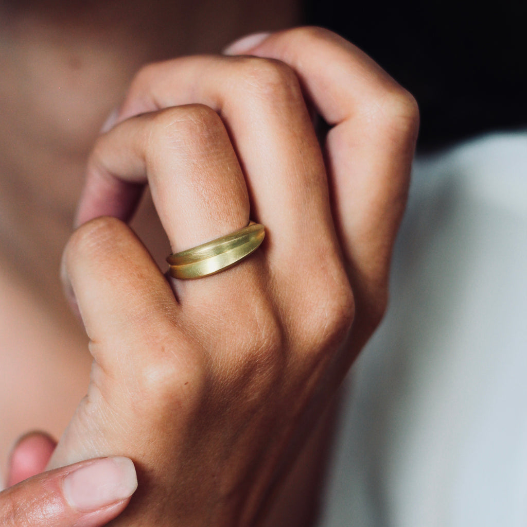 A chunky 18ct yellow gold ring with a matte finish, shown on model. By contemporary jewellery designer, Sarah Straussberg