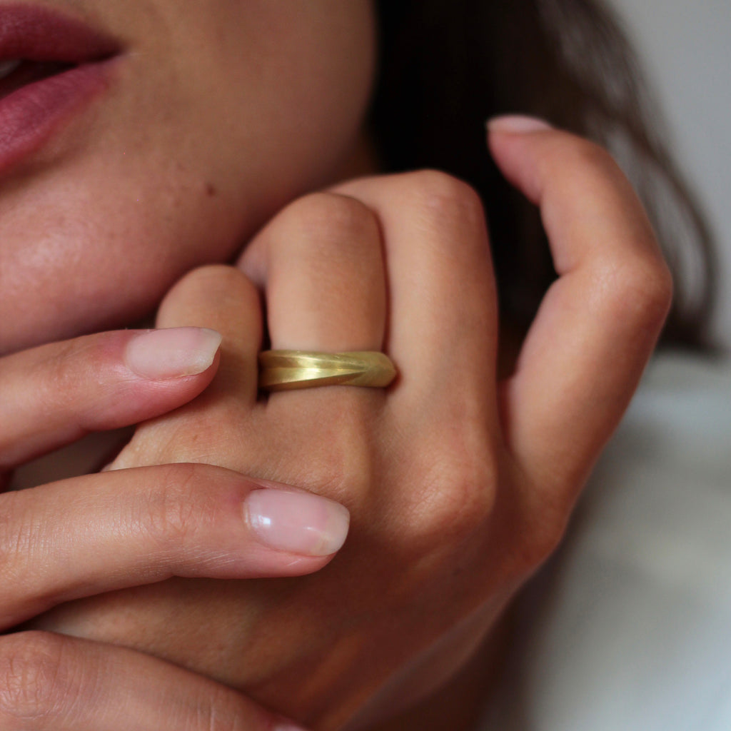 A chunky 18ct yellow gold ring with a matte finish, shown on model. By contemporary jewellery designer, Sarah Straussberg