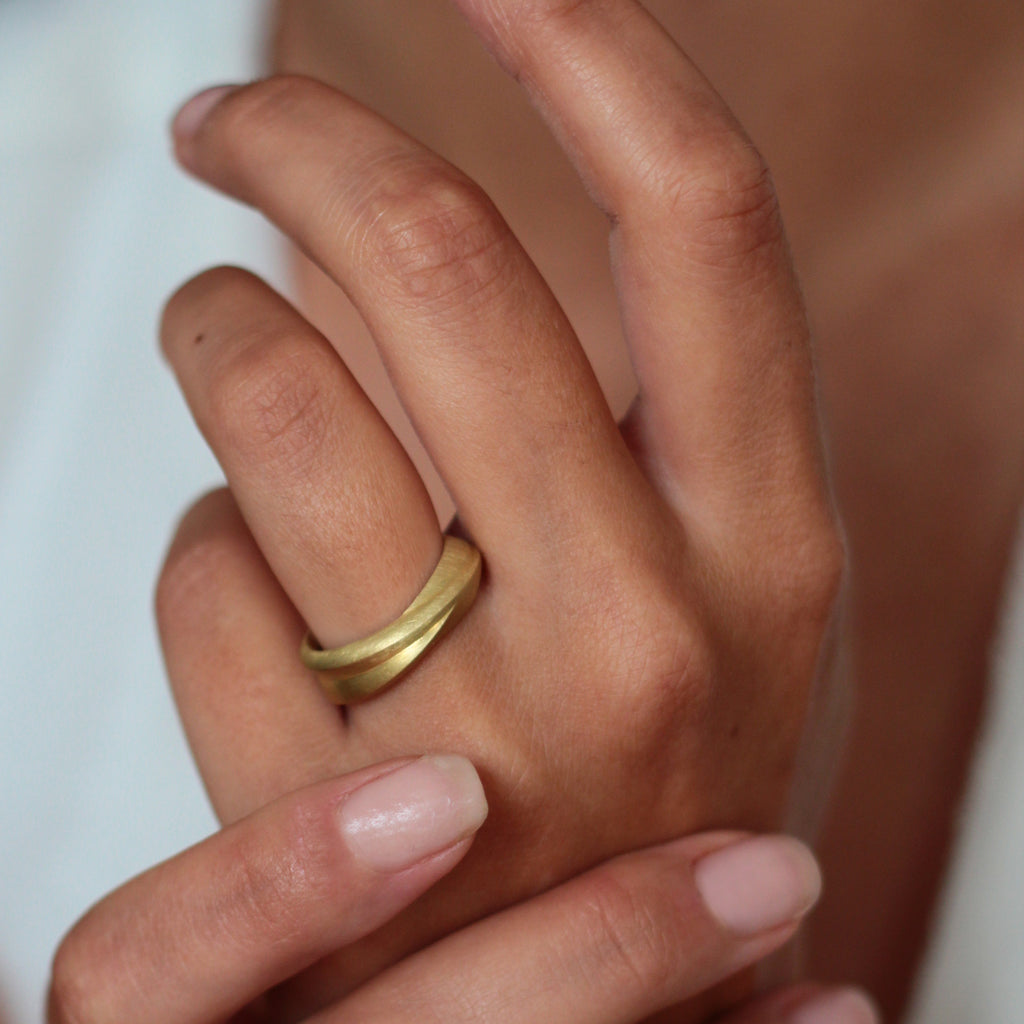 A chunky 18ct yellow gold ring with a matte finish, shown on model. By contemporary jewellery designer, Sarah Straussberg