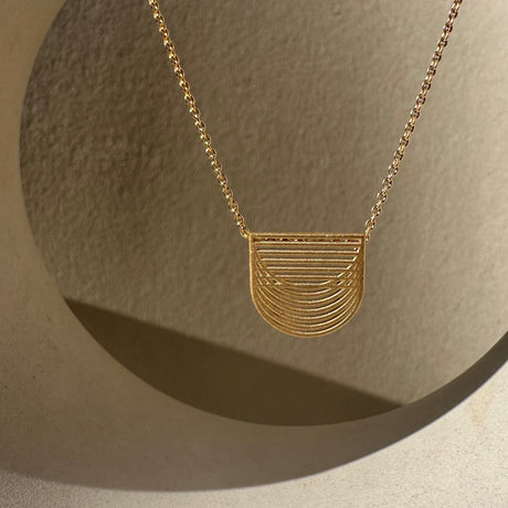 Gold plated pendant by contemporary jewellery designer, Sarah Straussberg