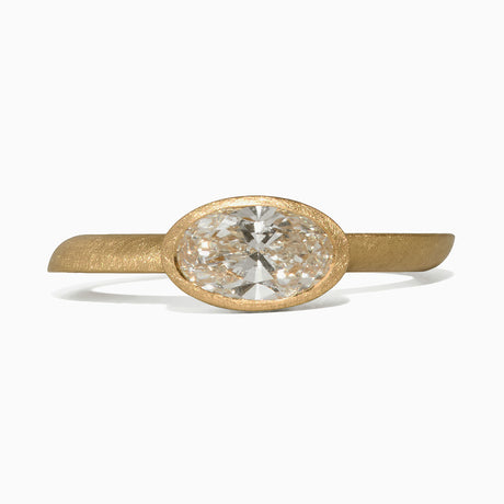 A gold ring with a textured band and an oval bezel setting holding an Oval-cut lab-grown diamond, shown against a clean white background. By contemporary jewellery designer, Sarah Straussberg