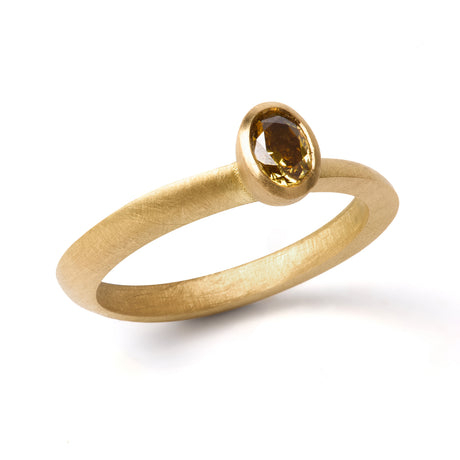 An olive green oval diamond ring with a bezel setting, crafted from 18ct yellow gold with a brushed matte finish.
