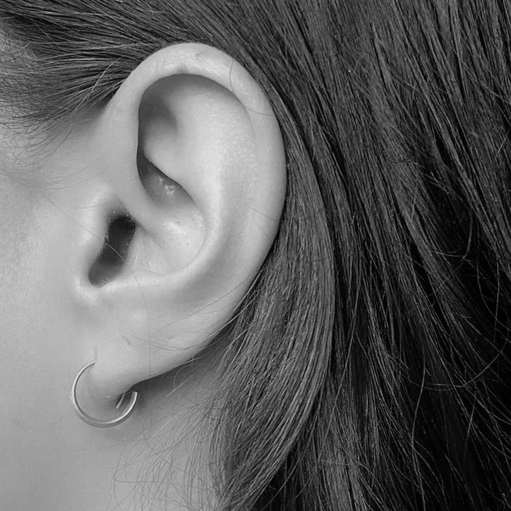 White gold Signature Hoops on model by contemporary jewellery designer, Sarah Straussberg