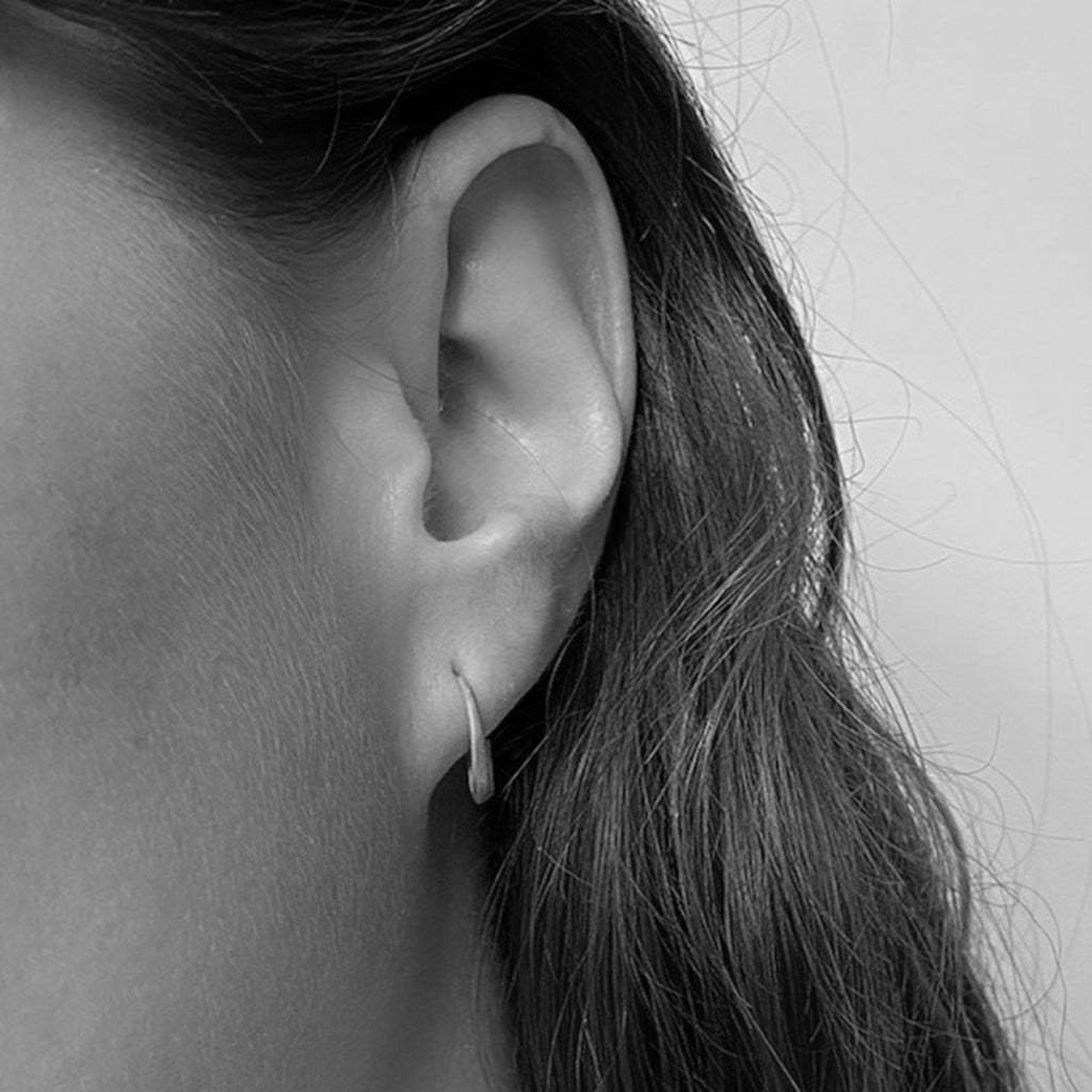 White gold Signature Hoops on model by contemporary jewellery designer, Sarah Straussberg