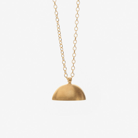 A gold pendant necklace with a brushed finish. The pendant has a semi-circular shape, by contemporary jewellery designer, Sarah Straussberg