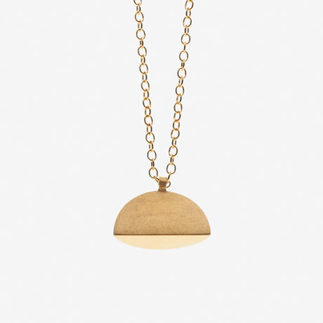 A gold pendant necklace with a brushed finish. The pendant has a semi-circular shape, by contemporary jewellery designer, Sarah Straussberg