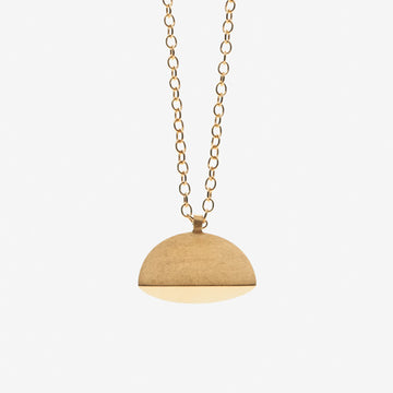 A gold pendant necklace with a brushed finish. The pendant has a semi-circular shape, by contemporary jewellery designer, Sarah Straussberg